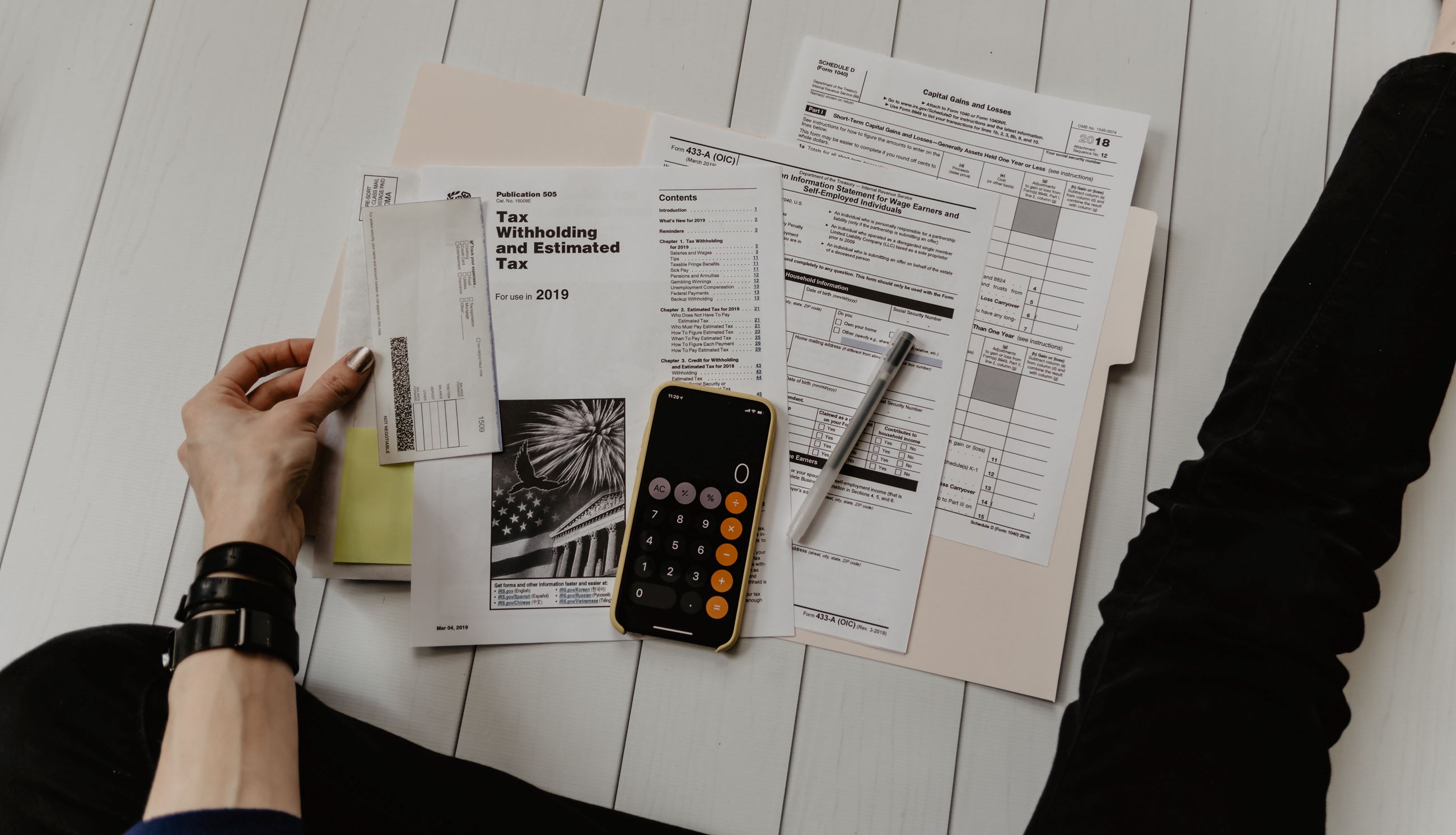 Tax forms spread out on floor with calculator